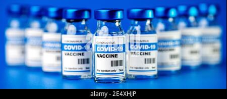 Covid-19 Impfstoff - Coronavirus Impfflaschen. Injektionsfläschchen auf blauem Hintergrund Stockfoto