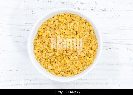 Bulgur Weizen Körner von oben Schüssel Holzbrett Holz Stockfoto