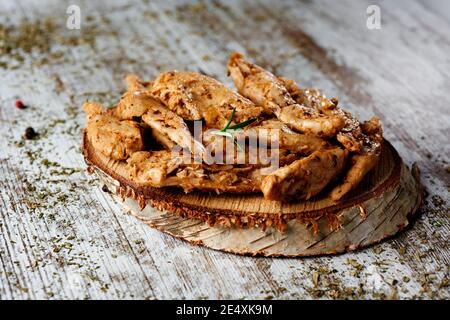 Nahaufnahme von einigen gekochten und gewürzten imitierten Hähnchenfleischstreifen auf einem Holztablett, auf einem rustikalen Holztisch platziert Stockfoto