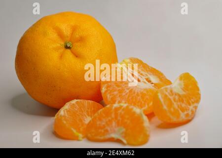 Nahaufnahme der Mandarin Orangen (Lukan) und geschälte Segmente auf Weiß Hintergrund Stockfoto