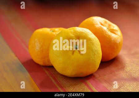 Nahaufnahme der Mandarin Orangen (Lukan-Sorte) auf rotem Tischläufer. Die Tradition, sie während des chinesischen Neujahrs auszutauschen, wird als "song gam" bezeichnet. Stockfoto