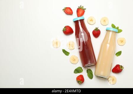 Flaschen mit Erdbeer- und Bananensaft auf weißem Hintergrund Stockfoto