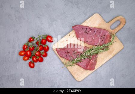 Rohes Rinderfleisch und Zutaten zum Kochen von Steaks. Stücke von rohen Steaks Stockfoto
