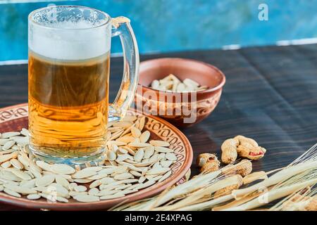 Sonnenblumenkerne, Erdnüsse und ein Glas Bier auf dunklem Tisch Stockfoto