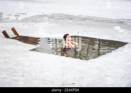 Junge oder Mann Baden und Schwimmen im kalten Wasser eines Sees oder Flusses, Kälte-Therapie, Eis schwimmen Stockfoto