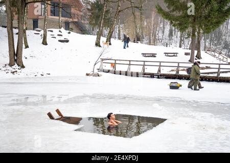 Junge oder Mann Baden und Schwimmen im kalten Wasser eines Sees oder Flusses, Kalttherapie, Eis schwimmen mit Wald oder Park auf dem Hintergrund Stockfoto