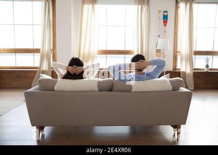 Rückansicht Junges Paar auf der Couch in moderner Wohnung entspannen Stockfoto