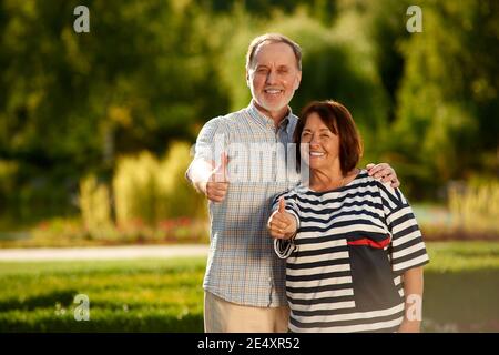 Das Rentnerehepaar zeigt Daumen nach oben. Stockfoto