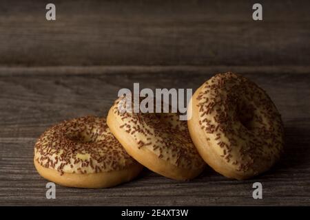 Leckere Ringdonuts mit Vanille-Glasur bedeckt, mit Streuseln gekrönt. Stockfoto