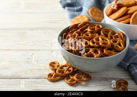 Serviette und Schüsseln mit Crackerkeksen auf einem Holztisch, ein rustikaler Crackerkeks-Snack zum Teilen Stockfoto