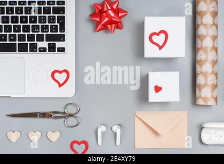 Geschenkverpackung Valentinstag Geschenke in der Nähe von modernen Gadgets auf grauen Tisch Draufsicht. Valentinstag-Konzept Stockfoto