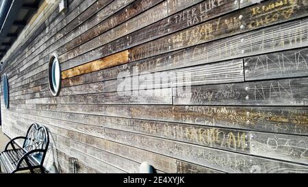 Seitenansicht von Graffiti in Holzplanken auf Gebäude zerkratzt Am RNLI-Gebäude am Southend Pier Stockfoto