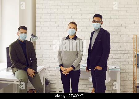 Die Menschen tragen Gesichtsmasken im Büro, kümmern sich um die Gesundheit der Kunden und Mitarbeiter Stockfoto