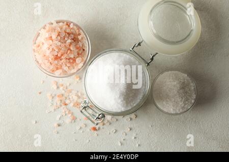 Schüsseln und Glas mit Salz auf weiß - grauen Tisch Stockfoto