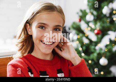Glücklich kaukasischen Mädchen lächelnd und Blick auf Kamera in gemütlich Zimmer Stockfoto