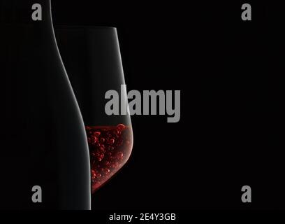 Nahaufnahme von Flasche und Weinglas mit Rotwein auf schwarzem Hintergrund. Stockfoto