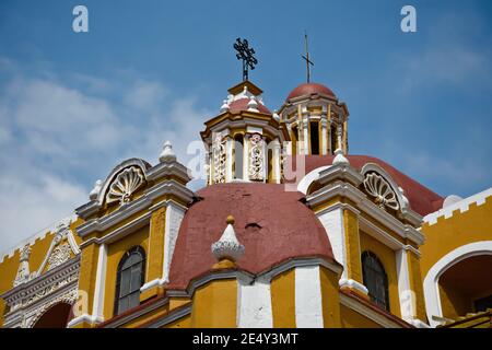 Außenansicht des barocken ehemaligen Klosters San Agustin mit den typischen ockerfarbenen Wänden und den Steinfassadengravuren in Atlixco, Puebla Mexiko. Stockfoto