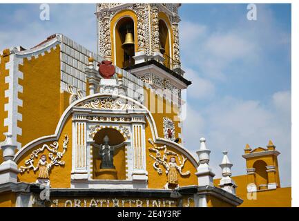 Außenansicht des barocken ehemaligen Klosters San Agustin mit den typischen ockerfarbenen Wänden und den Steinfassadengravuren in Atlixco, Puebla Mexiko. Stockfoto