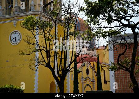 Außenansicht des barocken ehemaligen Klosters San Agustin mit den typischen ockerfarbenen Wänden und den Steinfassadengravuren in Atlixco, Puebla Mexiko. Stockfoto