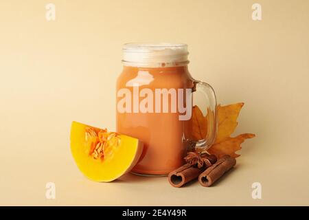Komposition mit Kürbislatte, Kürbis, Blatt und Zimt auf beigem Hintergrund Stockfoto