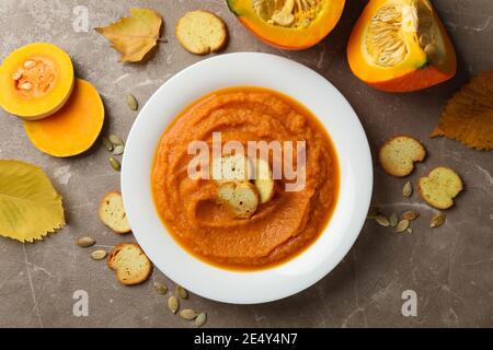 Komposition mit Teller Kürbispüree mit Croutons auf grauem Hintergrund, Draufsicht Stockfoto