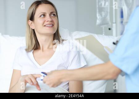 Arzt im Krankenhaus misst Puls von Frau zu Patient Stockfoto