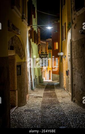 Enge gepflasterte Straße in Malcesine, am Ostufer des Gardasees in der Region Venetien in Italien. Stockfoto