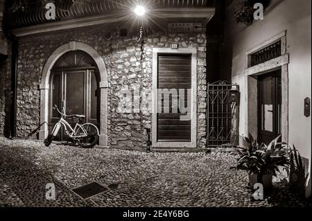 Enge gepflasterte Straße in Malcesine, am Ostufer des Gardasees in der Region Venetien in Italien. Stockfoto