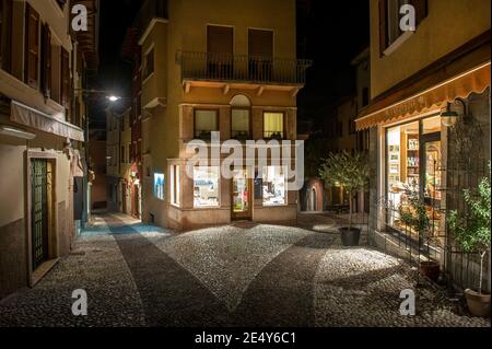 Geschäfte und gepflasterte Straßen in Malcesine, am Ostufer des Gardasees in der Region Venetien in Italien. Stockfoto