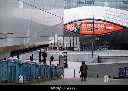 National Coronavirus Lockdown Three setzt sich im Stadtzentrum außerhalb des Grand Central Station Eingang, der verlassen ist, abgesehen von ein paar Menschen tragen Gesichtsmasken unter einer öffentlichen Gesundheit Beratung Werbekampagne mit Bully der Bull Ring Stier trägt eine Gesichtsmaske mit dem Slogan sein KEIN Stier. Bewahren Sie Ihre Stadt am 18. Januar 2021 in Birmingham, Großbritannien, sicher auf. . Nach dem jüngsten Anstieg der Fälle, einschließlich der neuen Variante von Covid-19, empfiehlt diese landesweite Sperre, die eine effektive Tier-fünf ist, allen Bürgern, der Botschaft zu folgen, zu Hause zu bleiben, den NHS zu schützen und Leben zu retten Stockfoto