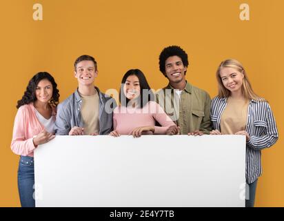 Diverse Teens fröhliche internationale Studenten halten große Banner mit kostenlos Platz und bereit zum Lernen Stockfoto