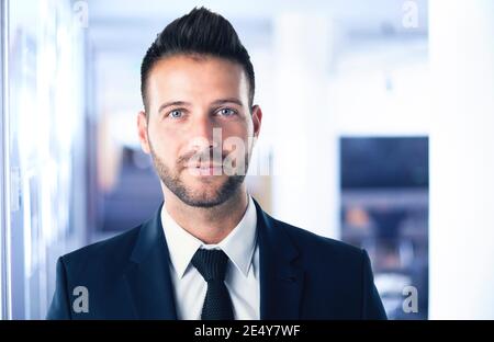 Nahaufnahme eines Geschäftsmanns, der im Büro steht und Anzug und Krawatte trägt. Stockfoto