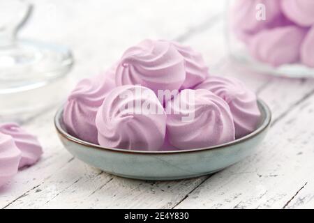 Hausgemachte milde Marshmallows auf blauen Teller aus nächster Nähe. Hausgemachte gesunde Süßigkeiten. Glas Glas von natürlichen Marshmallows auf dem Hintergrund. Stockfoto