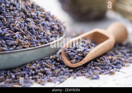 Blauer Teller mit getrocknetem Lavendel. Hölzerne Kugel von trockenen Lavendelblüten aus der Nähe. Stockfoto