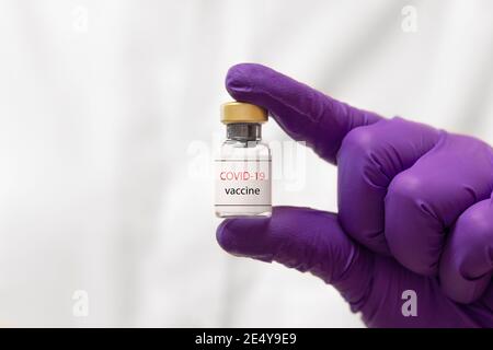 Impfstoff gegen COVID-19 (SARS-CoV-2). Konzept des Impfstoffs. Impfstoff in Entwicklung. Coronavirus-Impfstoff an der Hand mit Handschuhen gehalten Stockfoto
