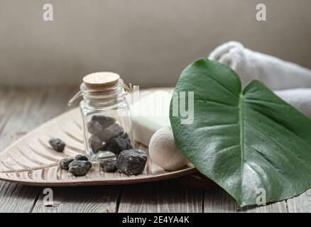Spa-Komposition mit Steinen, Badebombe, Seife und Handtuch. Hygiene- und Gesundheitskonzept. Stockfoto