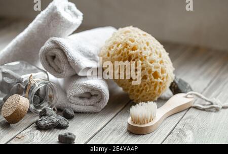 Spa-Komposition mit Steinen, Handtüchern, Waschlappen und Badebürste. Gesundheit und Schönheit Konzept. Stockfoto