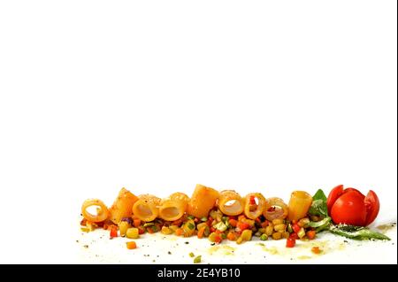 Mezze Maniche Pasta mit Tomatensauce auf gekochtem geschnittenem Gemüse Mit Kirschtomate und Basilikumblättern isoliert auf weißem Hintergrund An der Basis des Fr Stockfoto