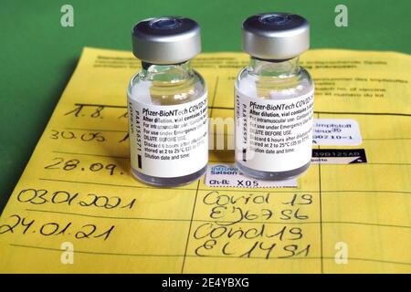 Symbolbild Corona-Impfung. Zwei Impfdosen und der Eintrag der ersten und zweiten Corona-Impfung in einem Impfpass einer mit dem COVID-19-mRNA-Impfstoff der Firma BioNTech geimpften Person. Dortmund, 25.01.2021 --- Corona-Impfsymbole. Zwei Impfdosen und die Aufnahme der ersten und zweiten Coronaimpfung in einen deutschen Impfpass einer mit dem COVID-19 mRNA-Impfstoff von BioNTech geimpften Person. Dortmund, den 25th. Januar 2021 Stockfoto