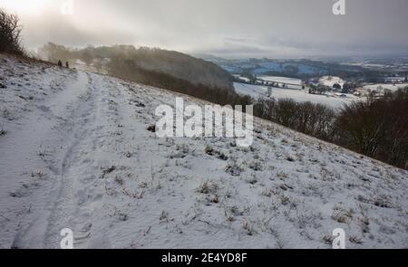 Ein kalter Januar Sonntagmorgen hoch, auf den Cotswolds in Gloucestershire, England nach nächtlichen Schneefall, mit der Sonne versucht, einen Auftritt zu machen Stockfoto