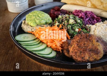 Mezze Platte mit Hummus, Babaganoush, Tabouli, Avocado-Pürree, Gurke, Rote Beete und glutenfreier Dosa. Stockfoto