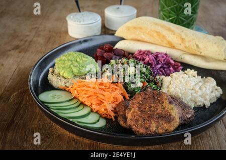 Mezze Platte mit Hummus, Babaganoush, Tabouli, Avocado-Pürree, Gurke, Rote Beete und glutenfreier Dosa. Stockfoto