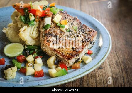 Gegrilltes Thunfischsteak mit Kartoffelpüree, sautiertem Gemüse und frischer Ananassalsa Stockfoto