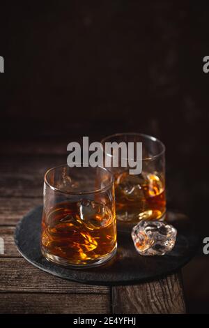 Zwei Gläser des Whiskys mit Eis isoliert auf einem Dunkler Hintergrund Stockfoto