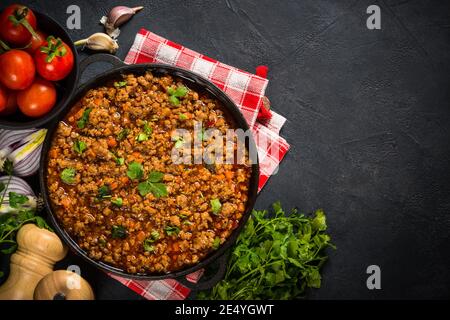 Bolognese steht in Eisenplatte am schwarzen Tisch. Stockfoto