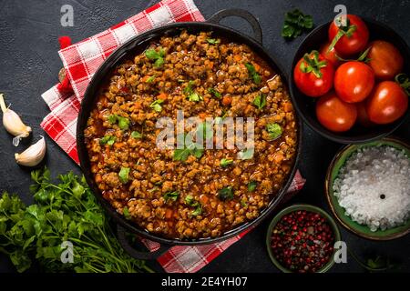 Bolognese steht in Eisenplatte am schwarzen Tisch. Stockfoto