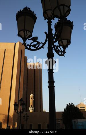 Kuwait-Stadt/Kuwait – 10. Januar 2021: Altes Moschee-Minarett mit Halbmondsymbol, das von modernen Wolkenkratzern in den Schatten gestellt wird Stockfoto