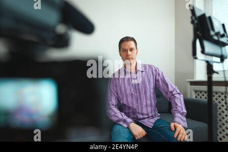 Schöner Mann, der zu Hause sein Videoblog aufnahm. Stockfoto