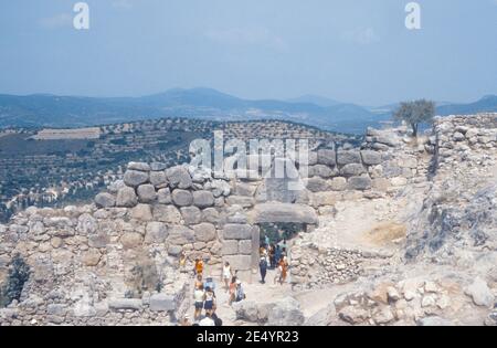 1986 Mycenae Griechenland - Mycenae Archäologische Stätte, Mycenae Löwentor und Zitadellenmauern, Mycenae, das Königreich von König Agamemnon, Herrscher der Griechen im Trojanischen Krieg. Die antike Stadt war von gigantischen Mauern umgeben, während der berühmteste Ort das Löwentor ist, der Eingang zur Stadt mit zwei weiblichen Steinlöwen darüber. Dies ist die Rückseite mit Touristen zu Fuß bis zur antiken Stadt, Archäologische Stätte der antiken Mykene, Mykene, Griechenland, EU, Europa Stockfoto