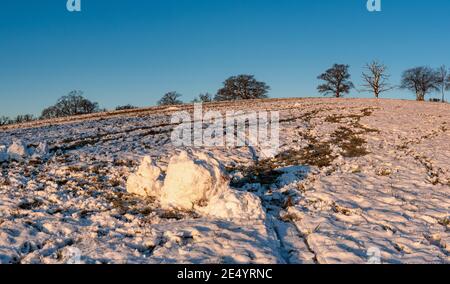Schnee und Schneebälle auf einem Feld von Harrow Weald in einem sonnigen Morgen, England Stockfoto